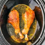 2 cooked turkey legs in a Crockpot slow cooker