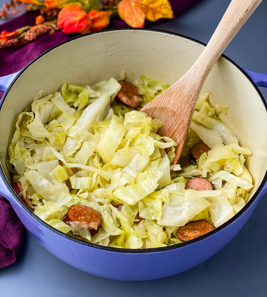 southern cooked cabbage in a large pot with a wooden spoon
