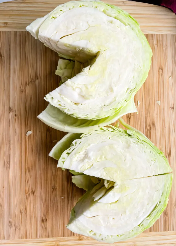 fresh cabbage sliced into wedges on a cutting board