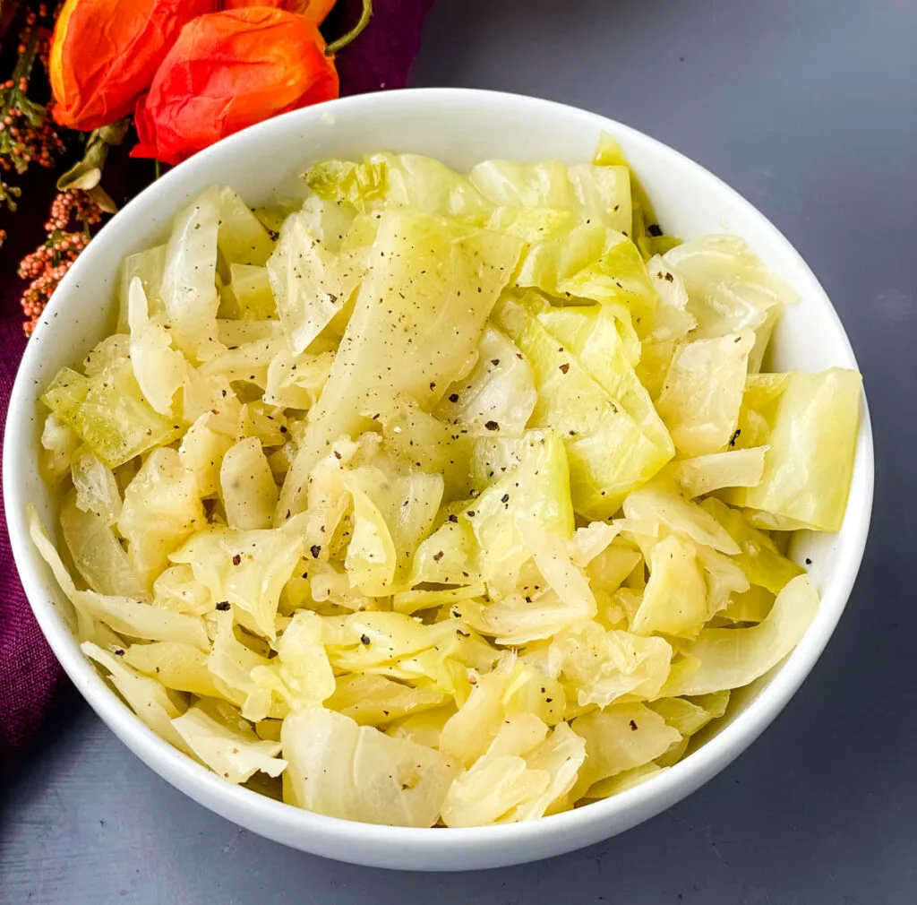 southern soul food cabbage in a white bowl sprinkled with pepper