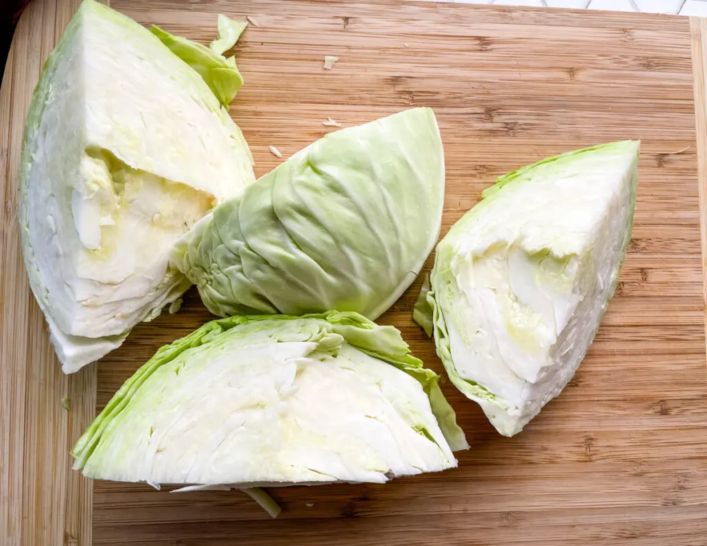 fresh cabbage sliced into wedges on a cutting board