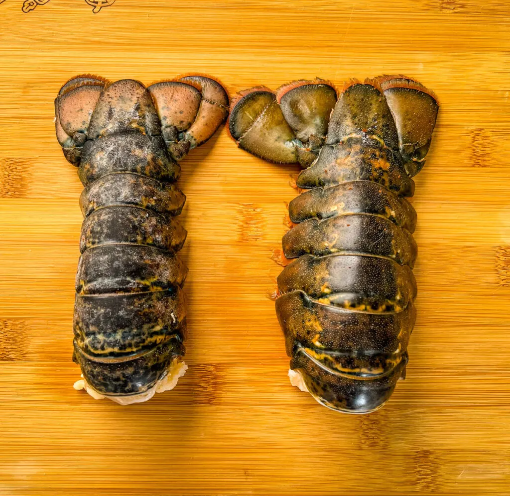 raw lobster tails on a cutting board