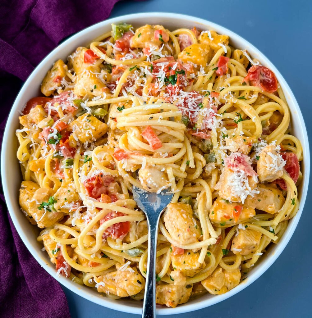 Southern chicken spaghetti in a white bowl with a fork full of spaghetti