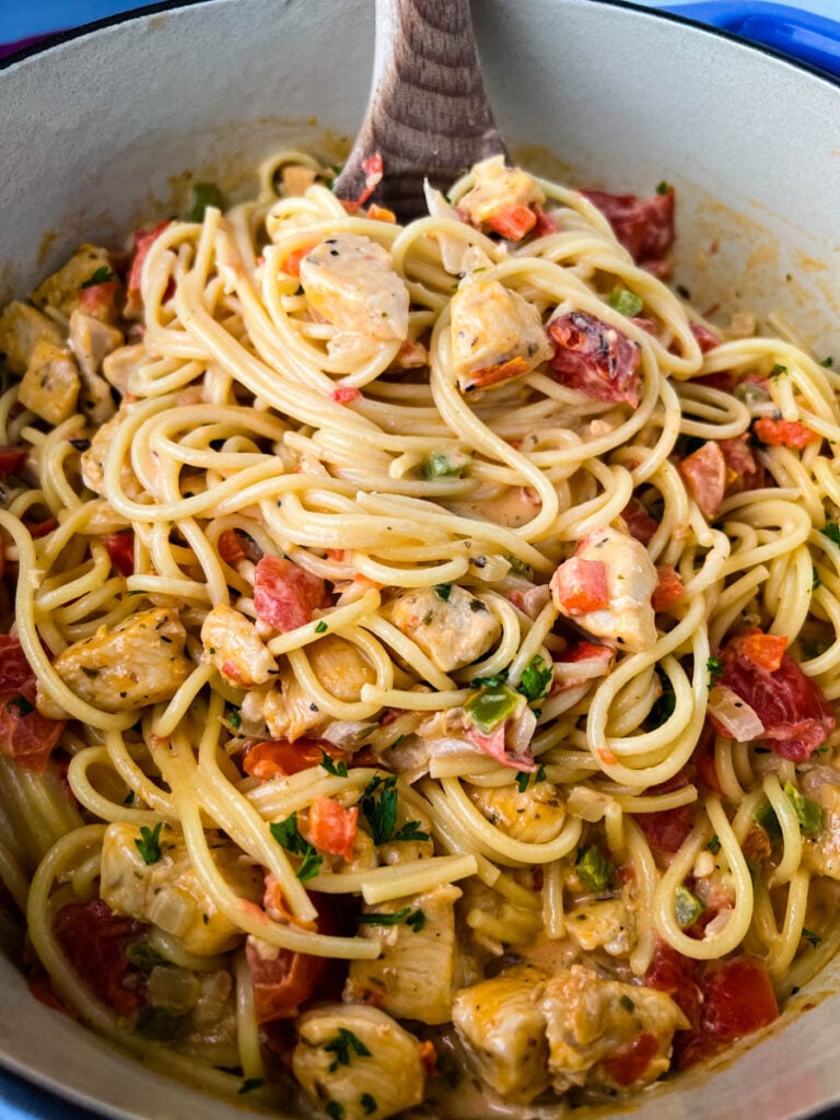 southern chicken spaghetti in a Dutch oven with a wooden spoon