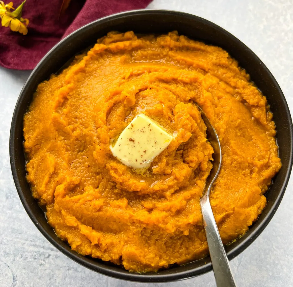 mashed sweet potatoes in a bowl with butter and brown sugar
