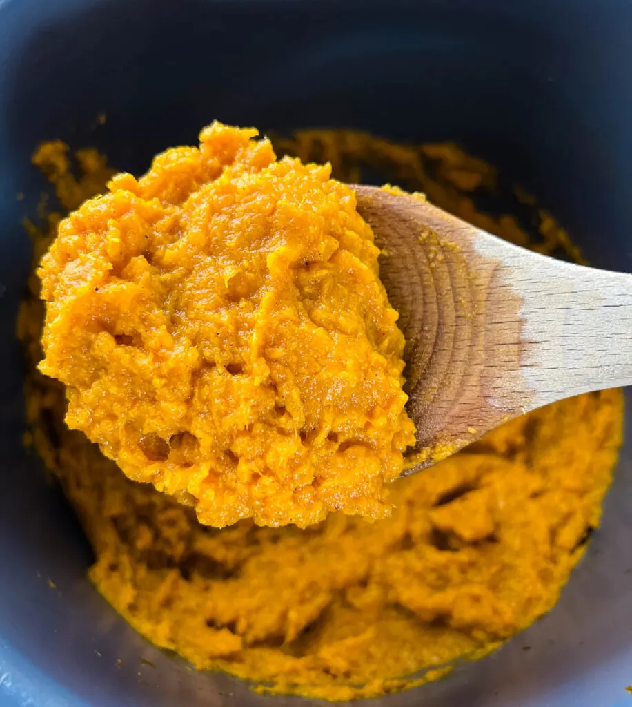 a wooden spoonful of mashed sweet potatoes
