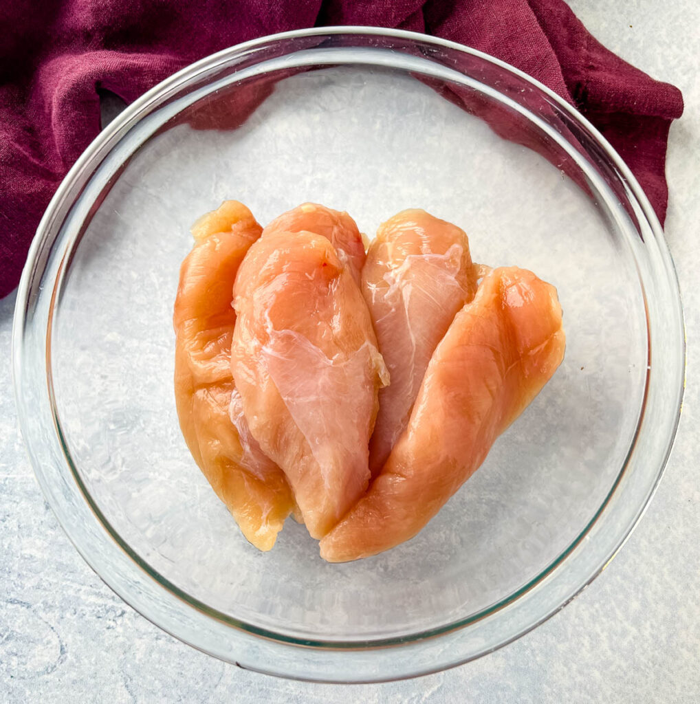 raw chicken tenderloins in a glass bowl