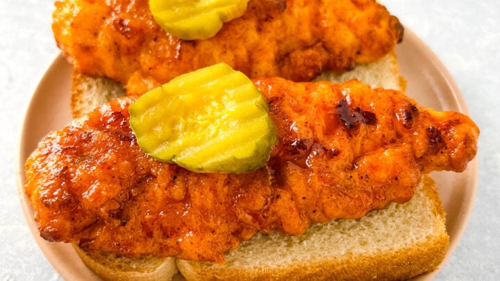 Nashville hot chicken tenders on bread with pickles