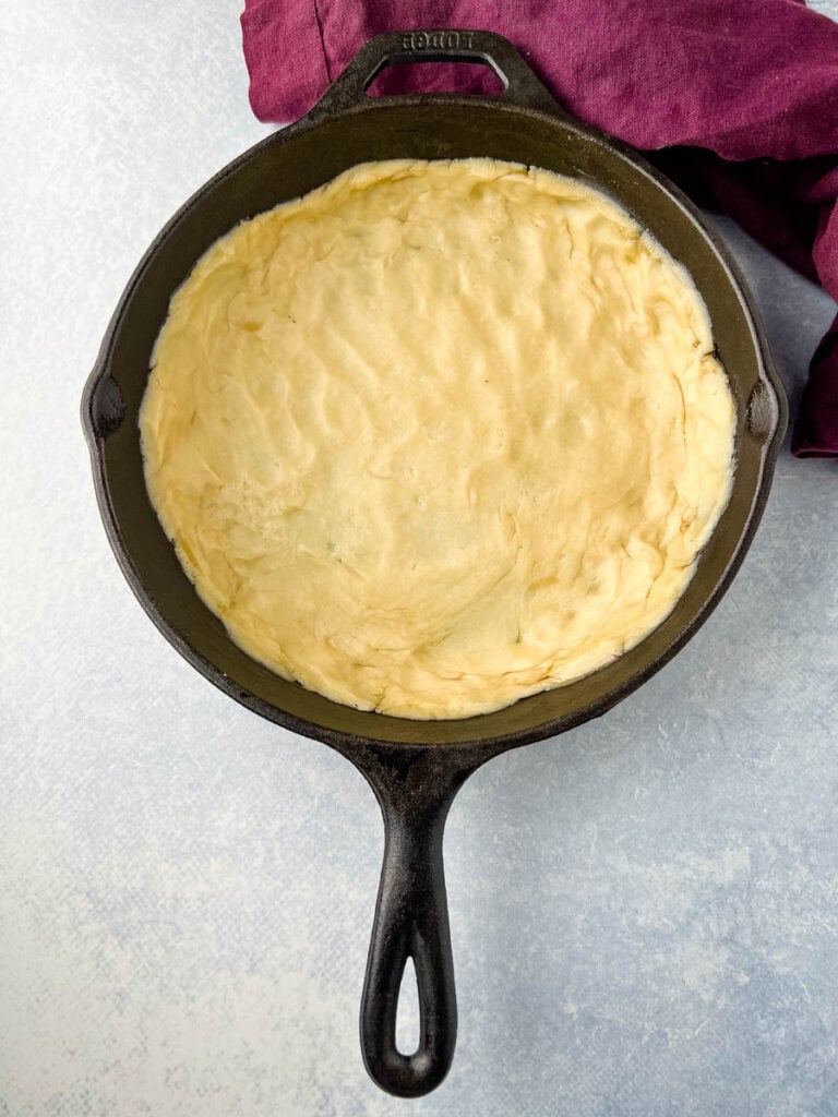 unbaked pie crust in bottom of cast iron skillet