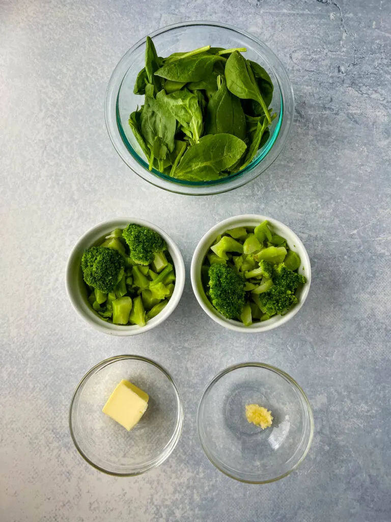 fresh spinach, steamed broccoli, butter, and garlic in separate bowls