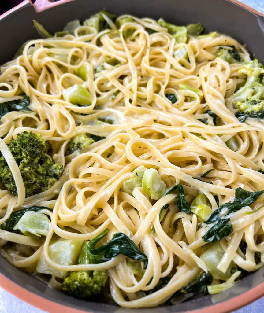 lemon pasta in a pan with spinach and broccoli