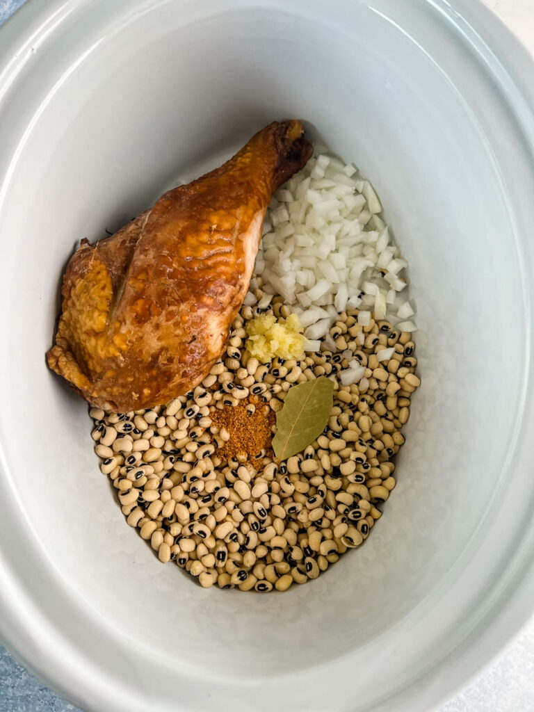 dried black eyed peas, onions, bay leaf, spices, and smoked turkey in slow cooker Crockpot