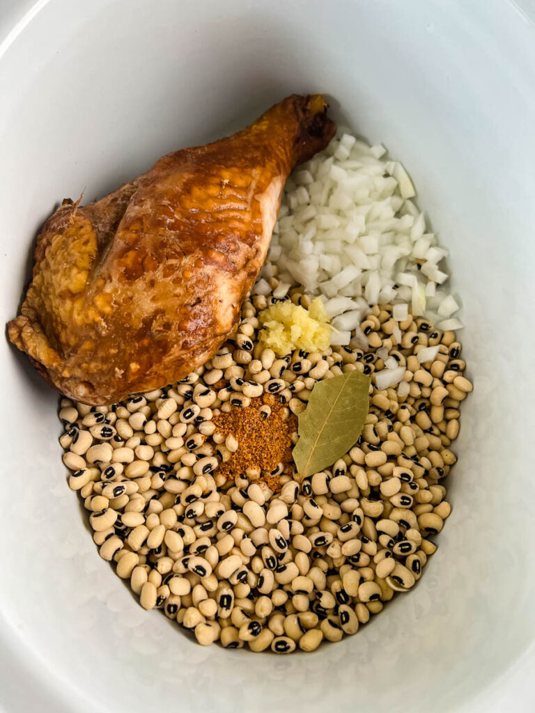 dried black eyed peas, onions, bay leaf, spices, and smoked turkey in slow cooker Crockpot