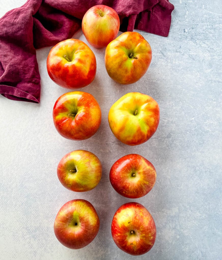 fresh Honeycrisp and Fuji apples on a flat surface