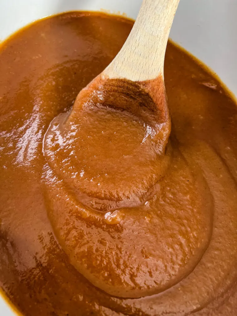 sugar free apple butter in a slow cooker with a wooden spoon