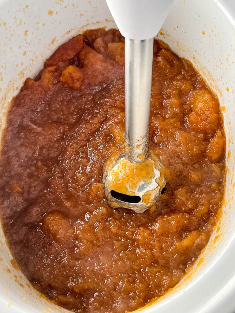 sugar free apple butter in a slow cooker with an immersion blender