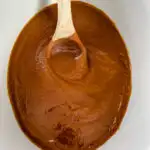 sugar free apple butter in a slow cooker with a wooden spoon