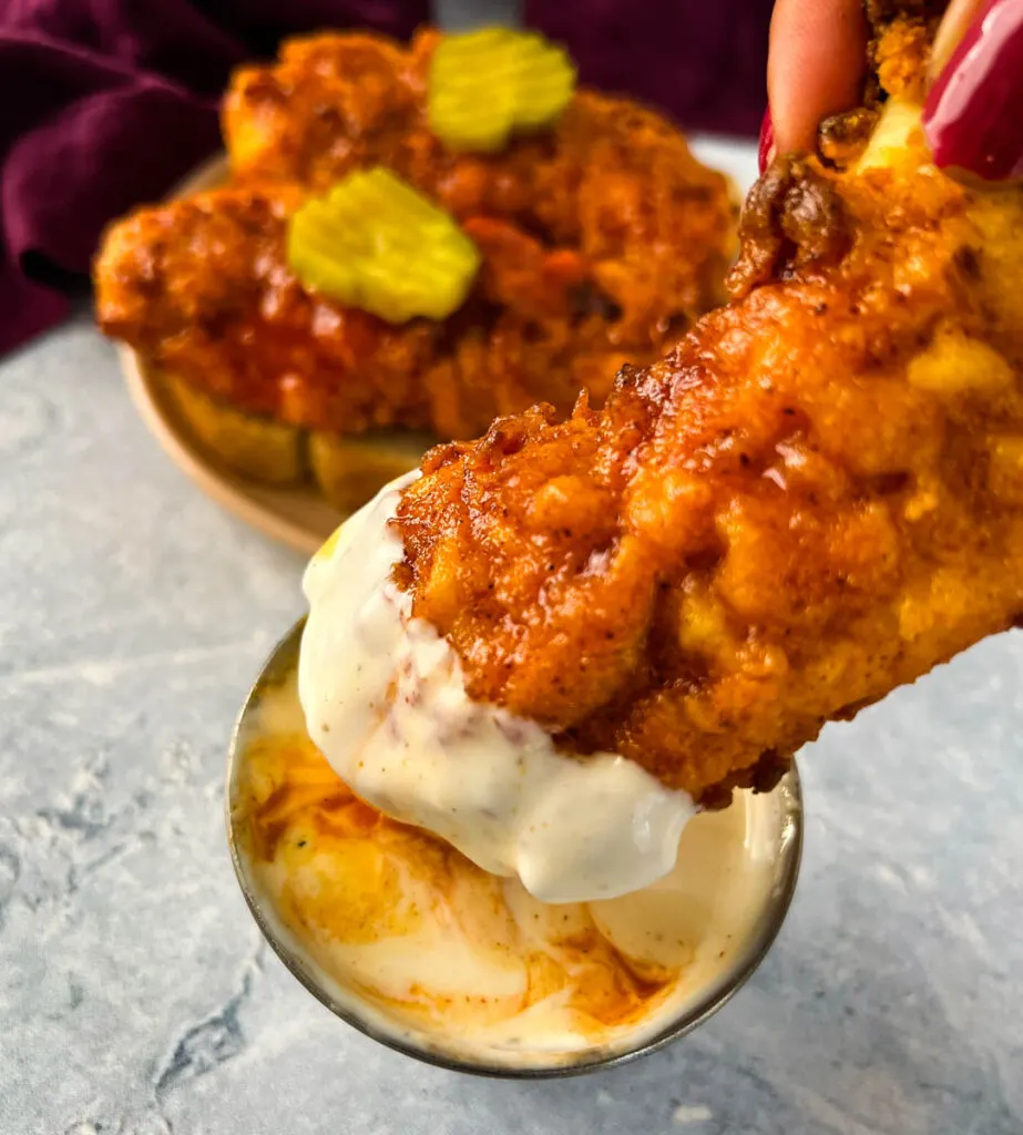 Nashville hot chicken tender dipped in sauce