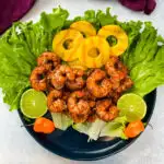 jerk shrimp on lettuce with pineapples, limes, and fresh peppers