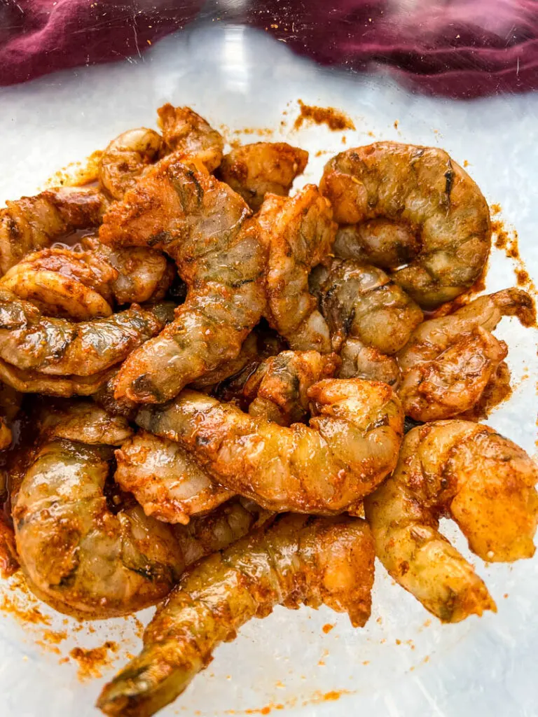 raw jerk shrimp in glass bowl with jerk marinade