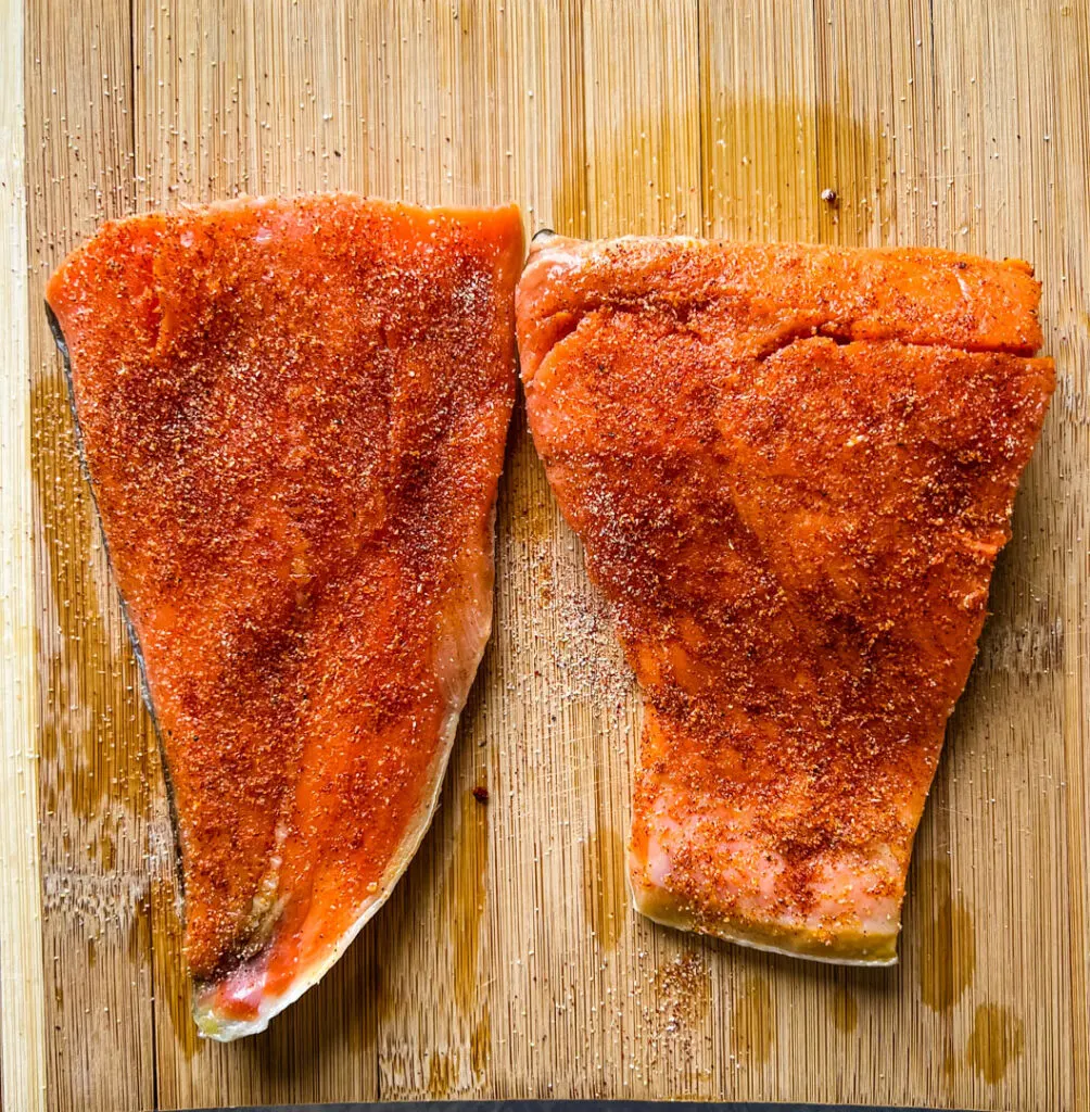 raw seasoned salmon on a cutting board