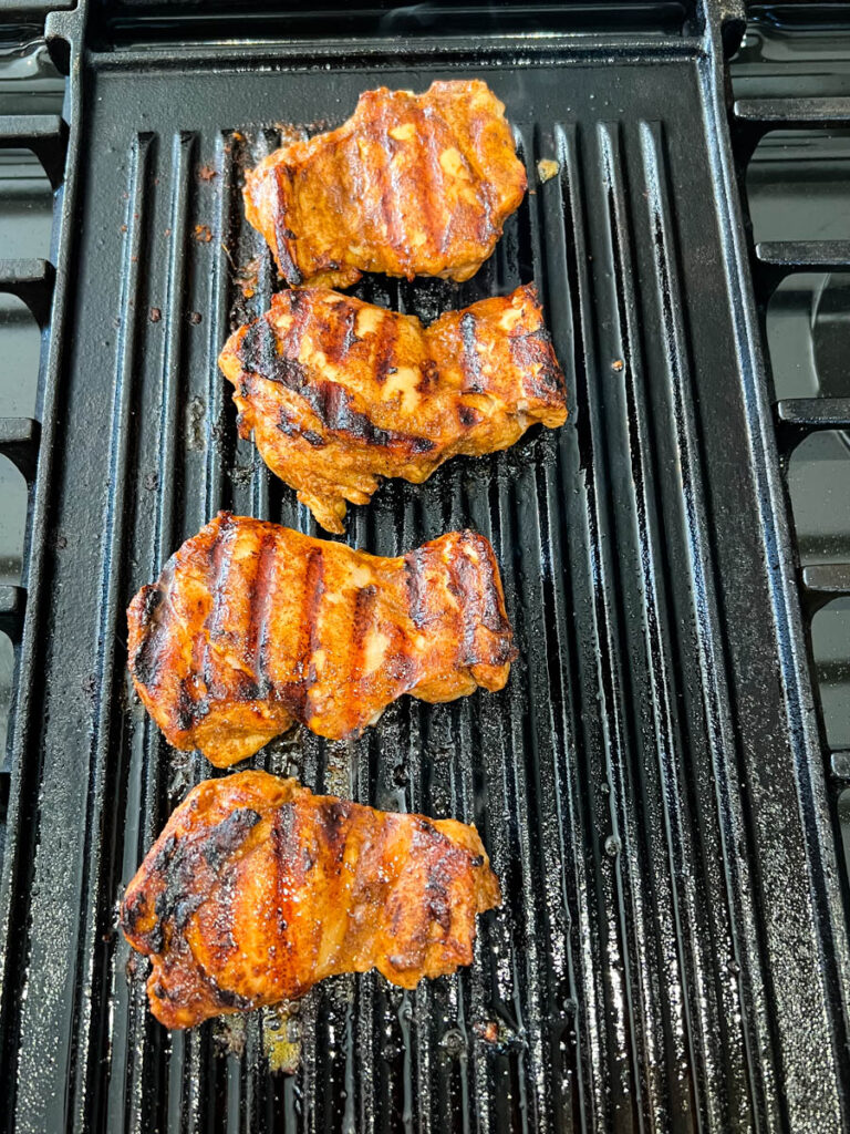 cooked jerk chicken thighs on a grill pan