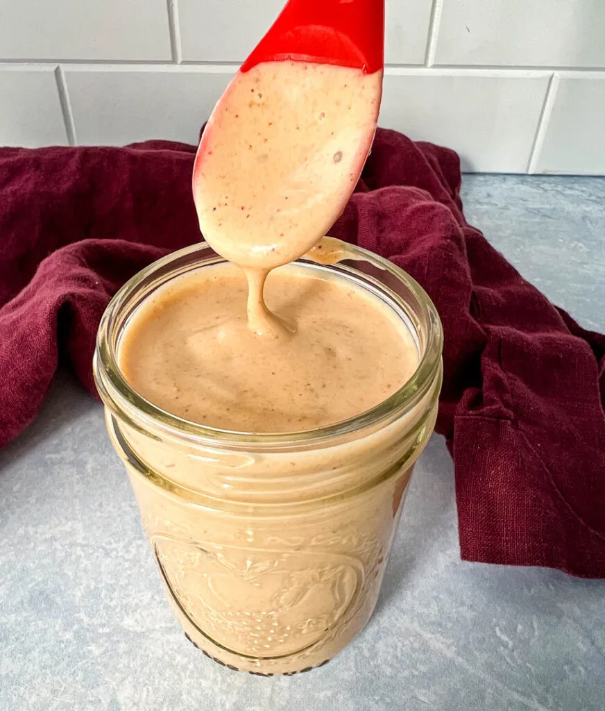 a spoonful of southwest salad dressing in a glass jar