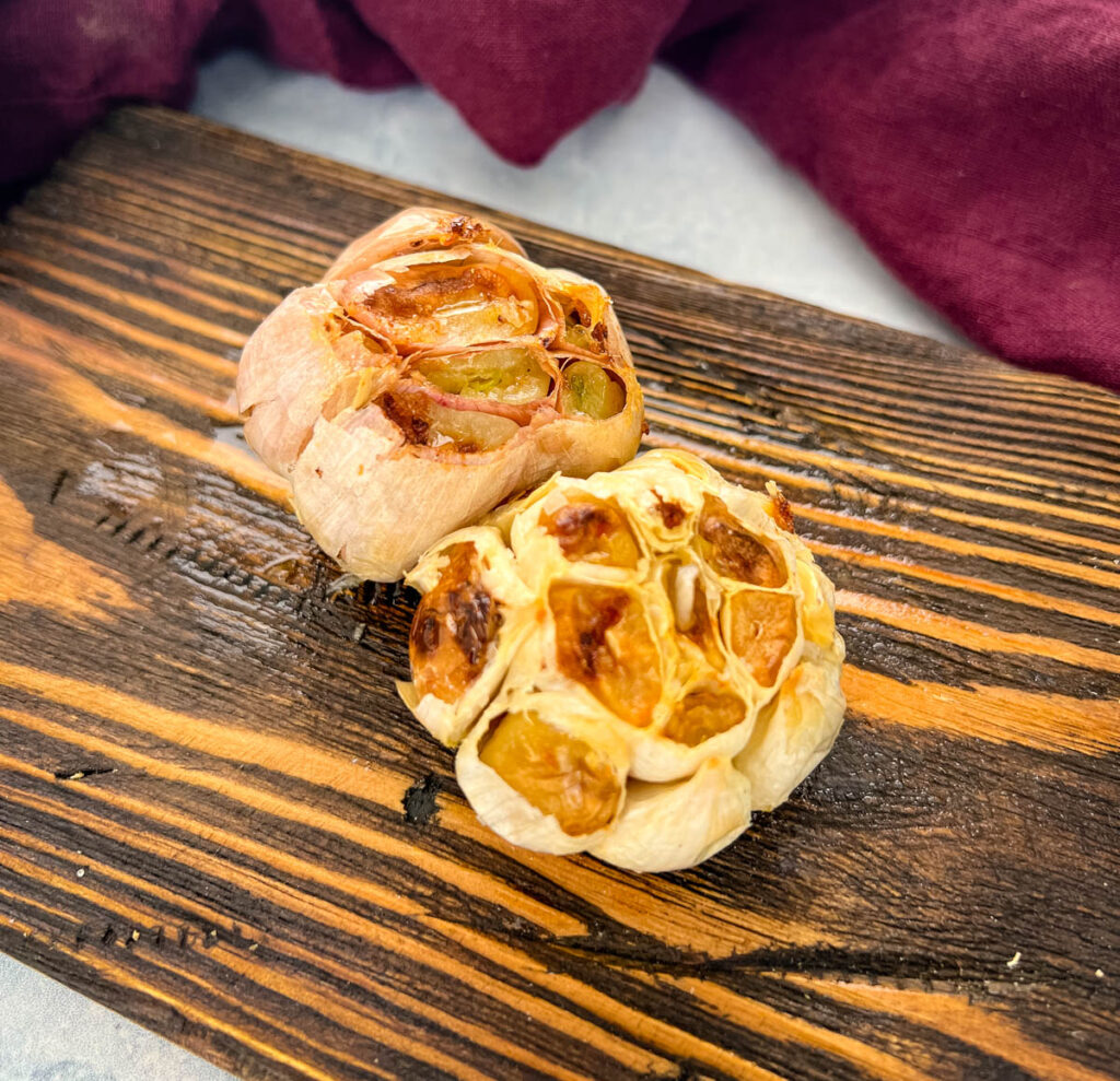 air fryer roasted garlic on a wooden plate