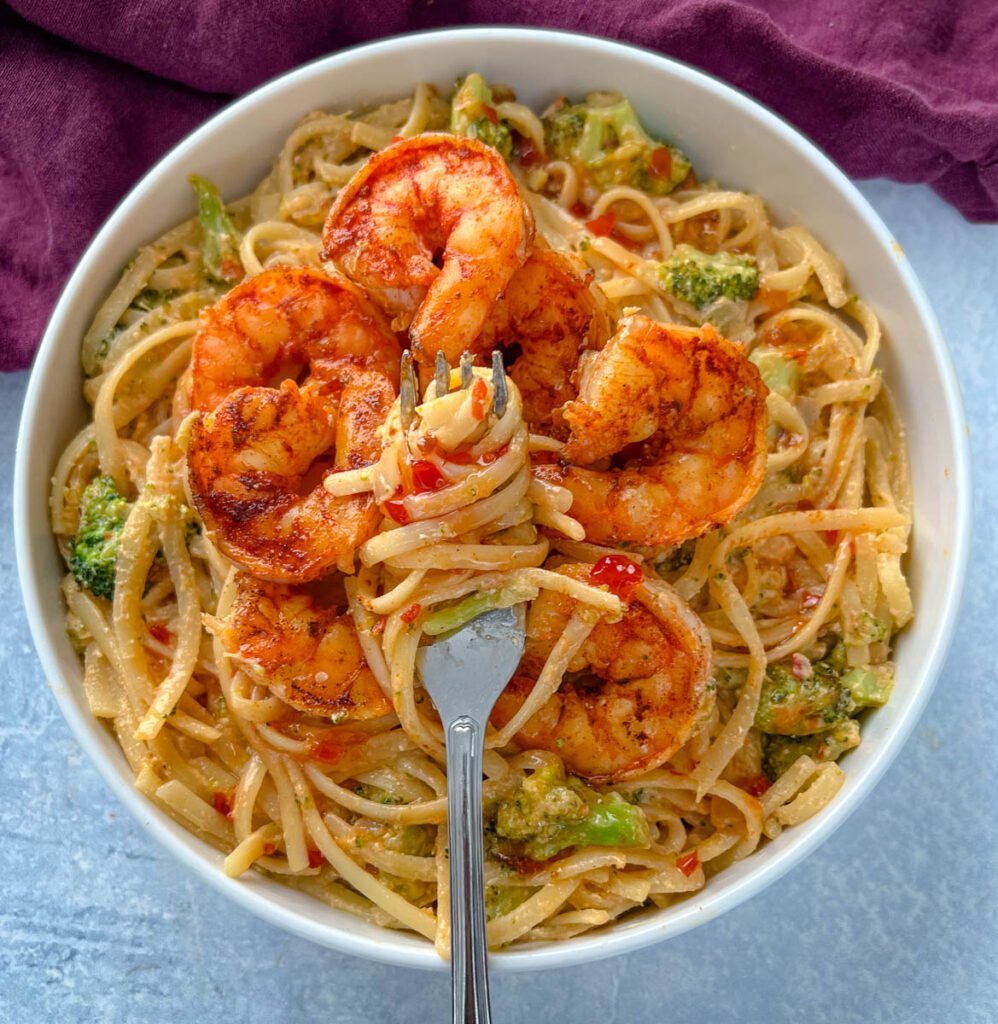 bang bang shrimp pasta in a white bowl with a fork