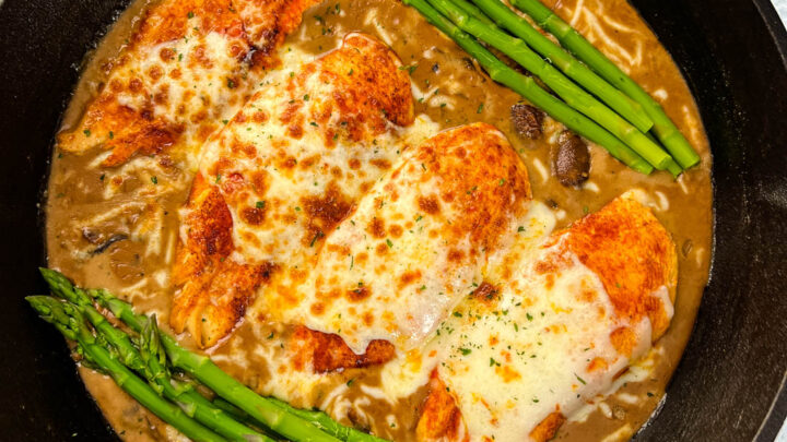 Cheesecake factory copycat chicken Madeira in a skillet with asparagus