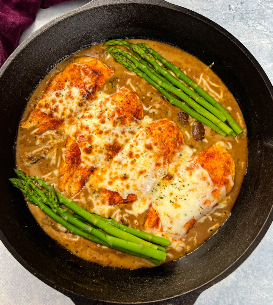 Cheesecake factory copycat chicken Madeira in a skillet with asparagus