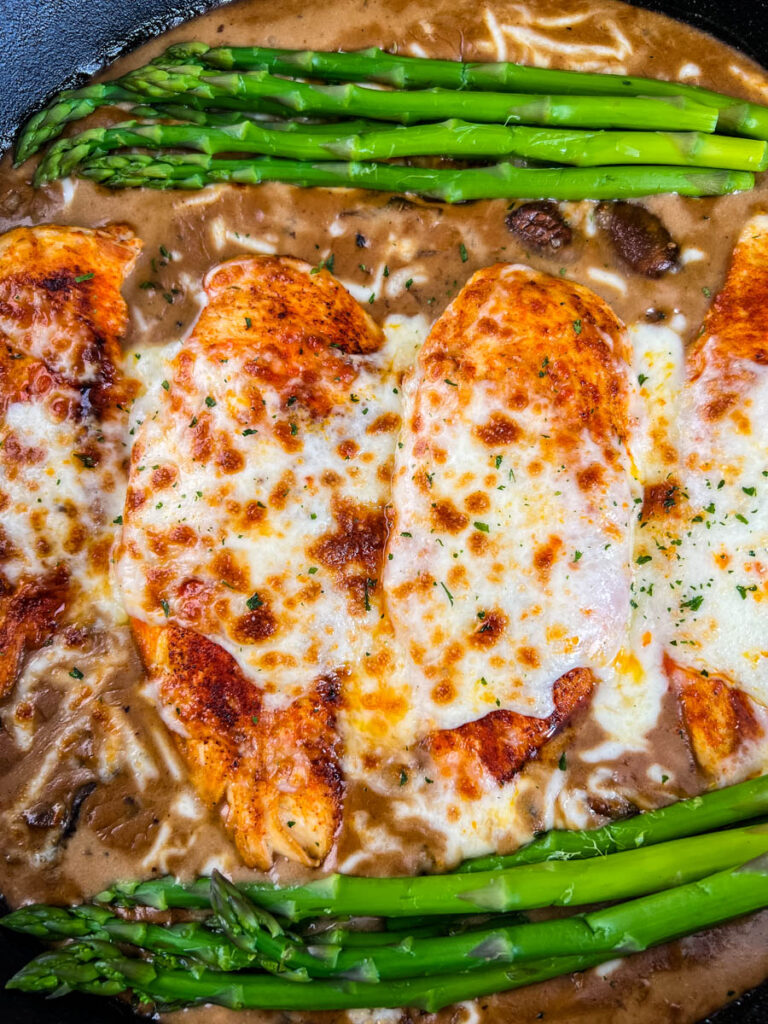 Cheesecake factory copycat chicken Madeira in a skillet with asparagus