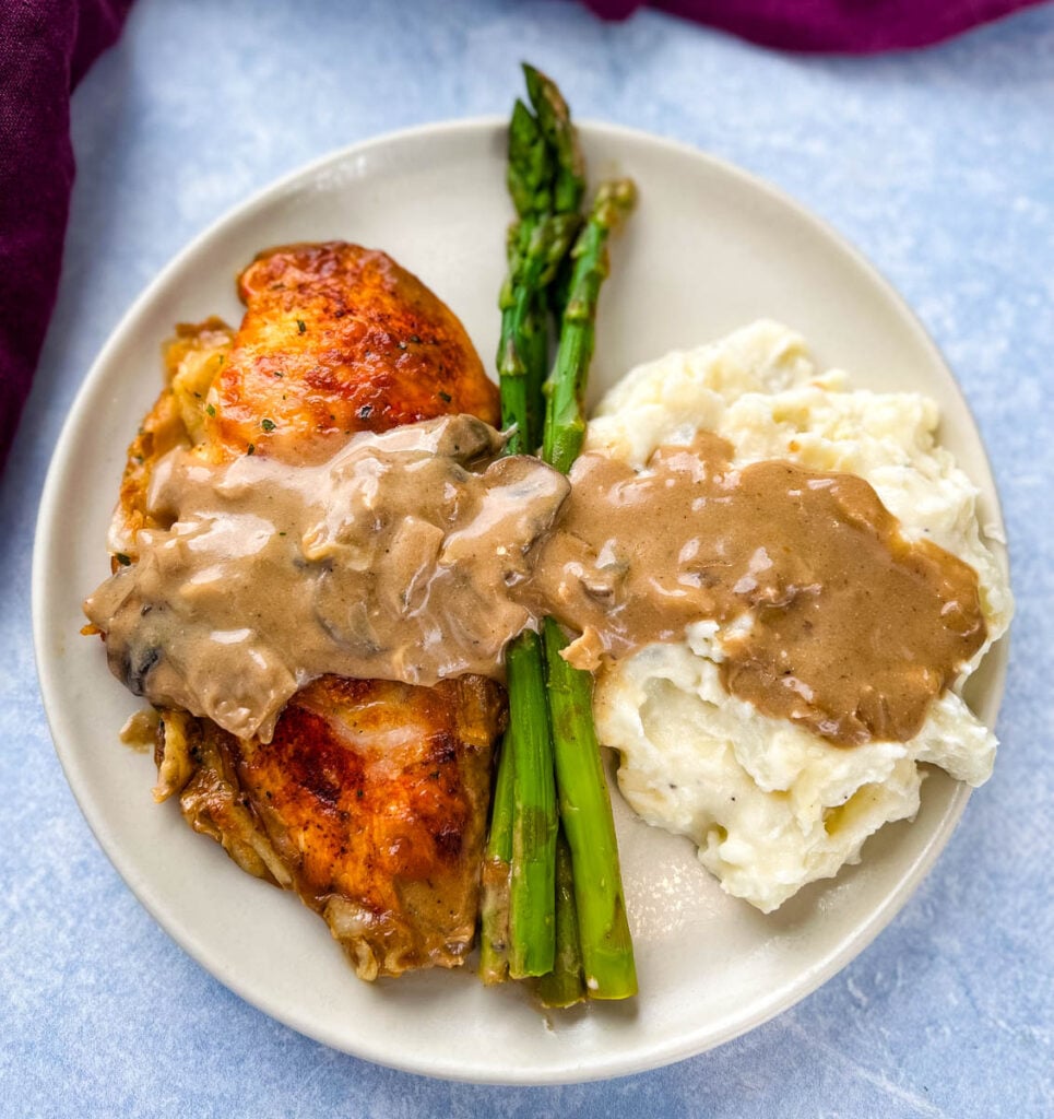 Chicken Madeira with mashed potatoes and asparagus on a plate