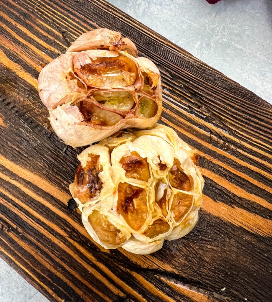 roasted garlic on a wooden plate