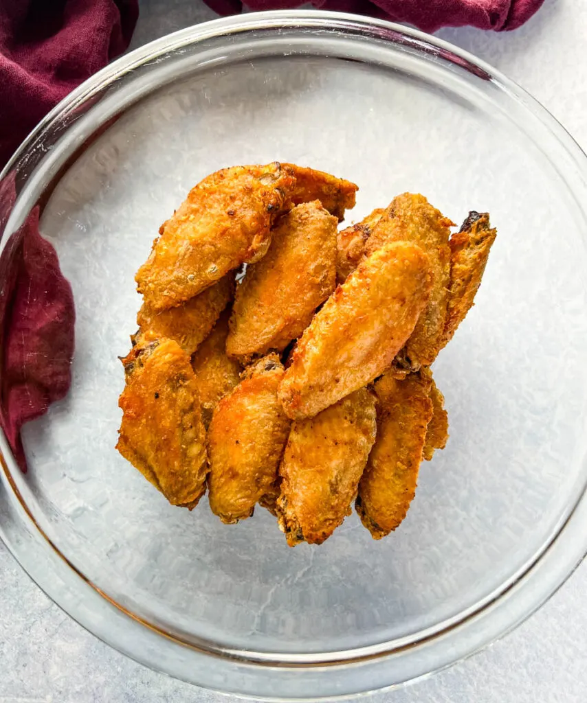 breaded chicken wings in a glass bowl