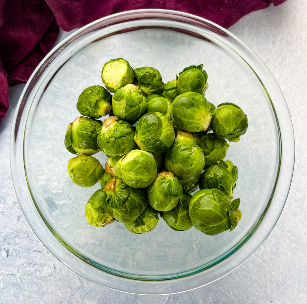 raw fresh brussels sprouts in a glass bowl