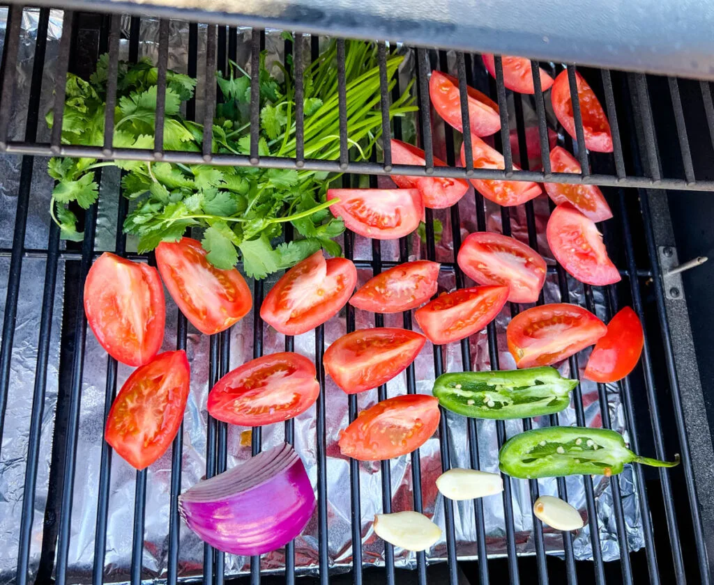 tomatoes, onions, cilantro, and garlic on a Traeger smoker