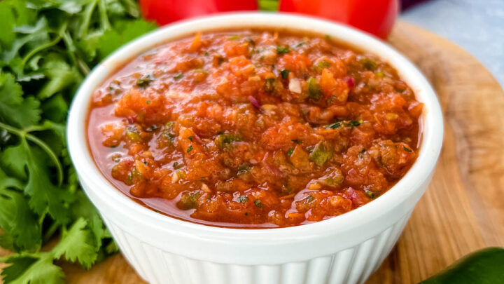 smoked salsa in a white bowl on a platter with fresh tomatoes, cilantro, and jalapeno