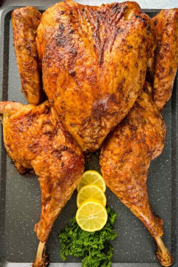 smoked turkey with lemons and parsley on a table
