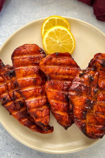 Traeger smoked chicken breasts on a plate with lemons