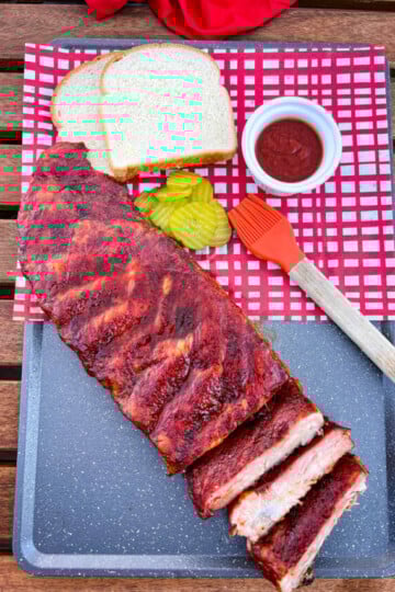 Traeger smoked ribs on a plate with pickles and white bread