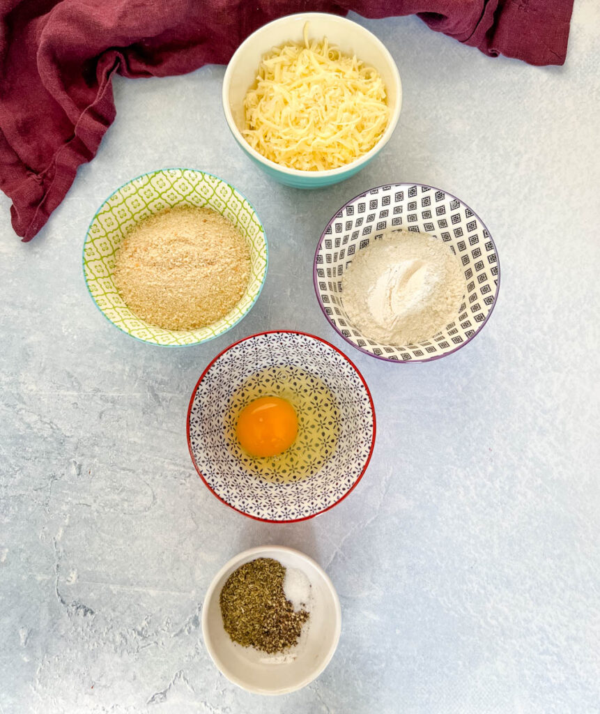 mozzarella cheese, breadcrumbs, flour, egg, and Italian seasoning in separate bowls