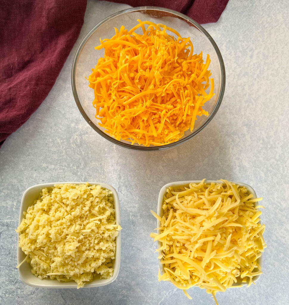 cheddar cheese, gouda cheese, and Gruyère cheese in separate bowls