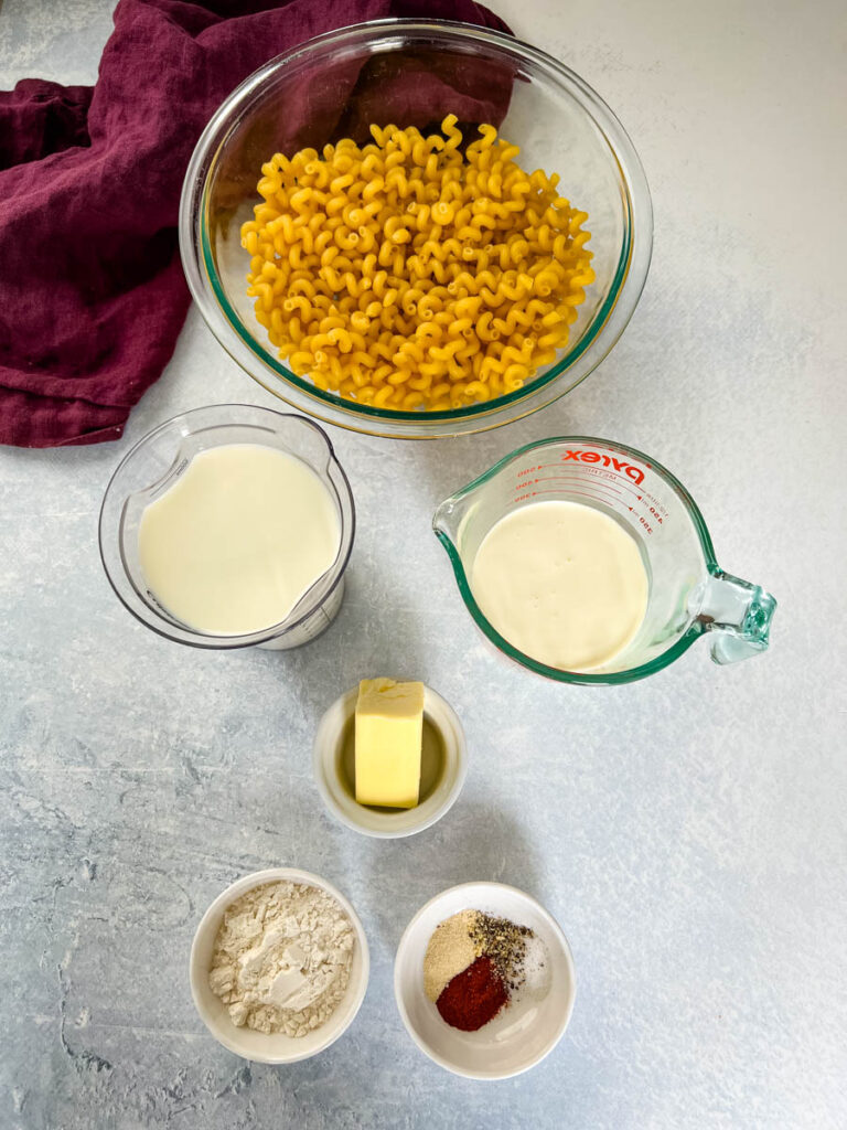 pasta, milk, heavy whipping cream, butter, spices, and flour in separate bowls