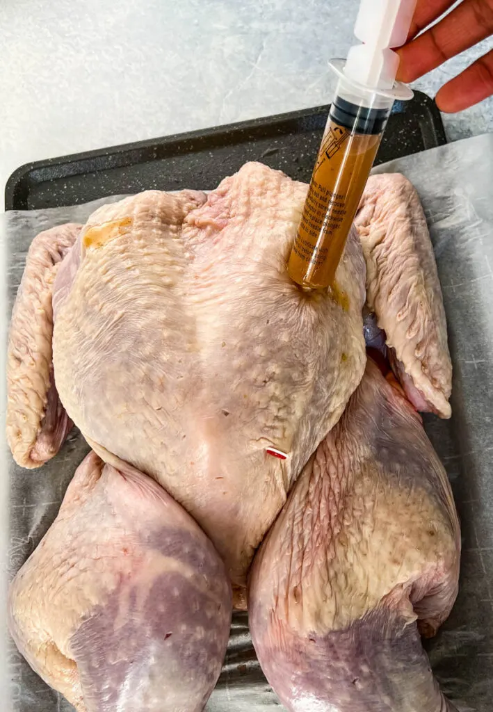 injecting marinade into raw turkey