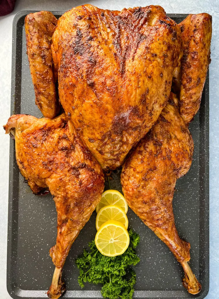 smoked turkey with lemons and parsley on a table