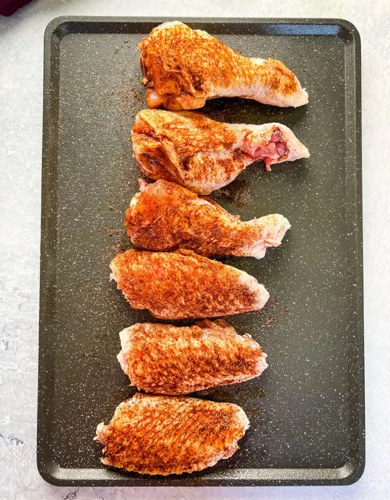 raw, seasoned turkey wings on a flat surface