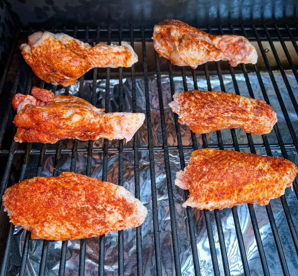 raw, seasoned turkey wings on a Traeger pellet grill