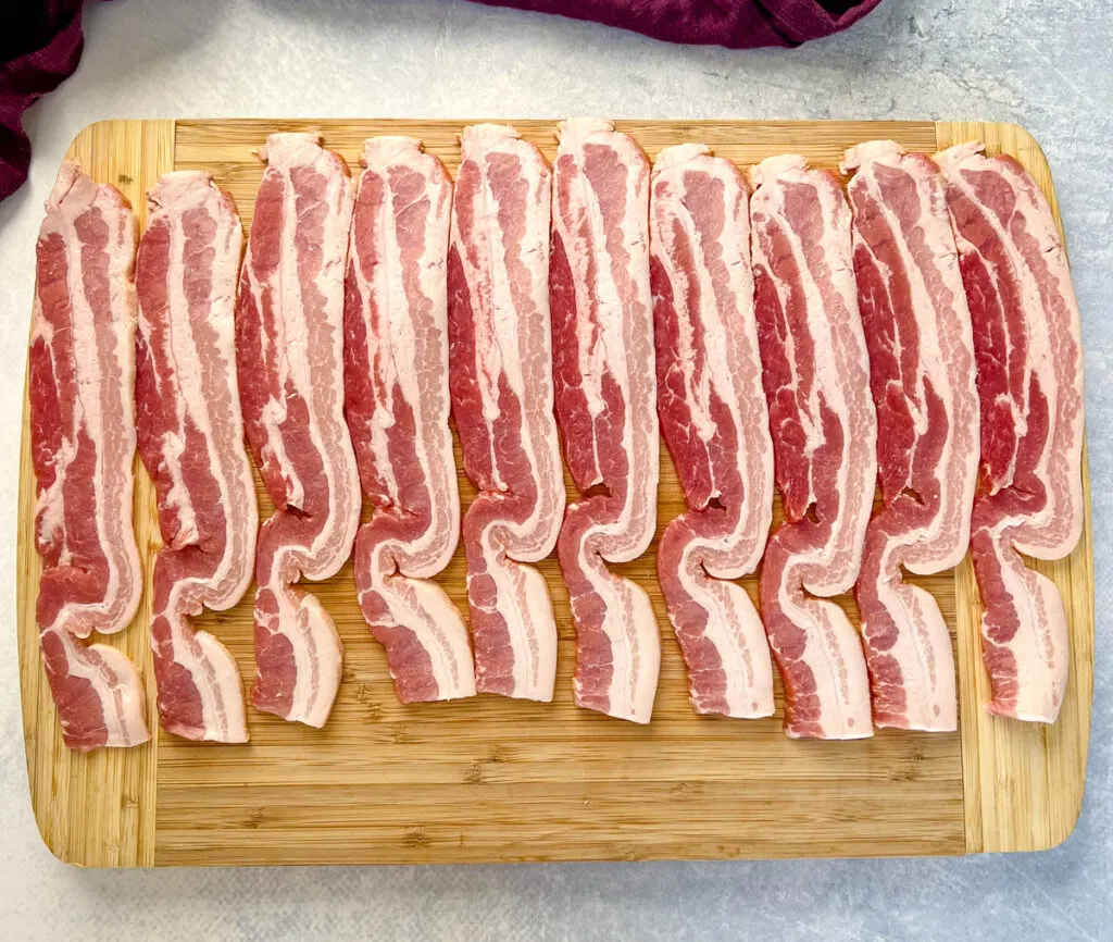 uncooked thick bacon on a cutting board