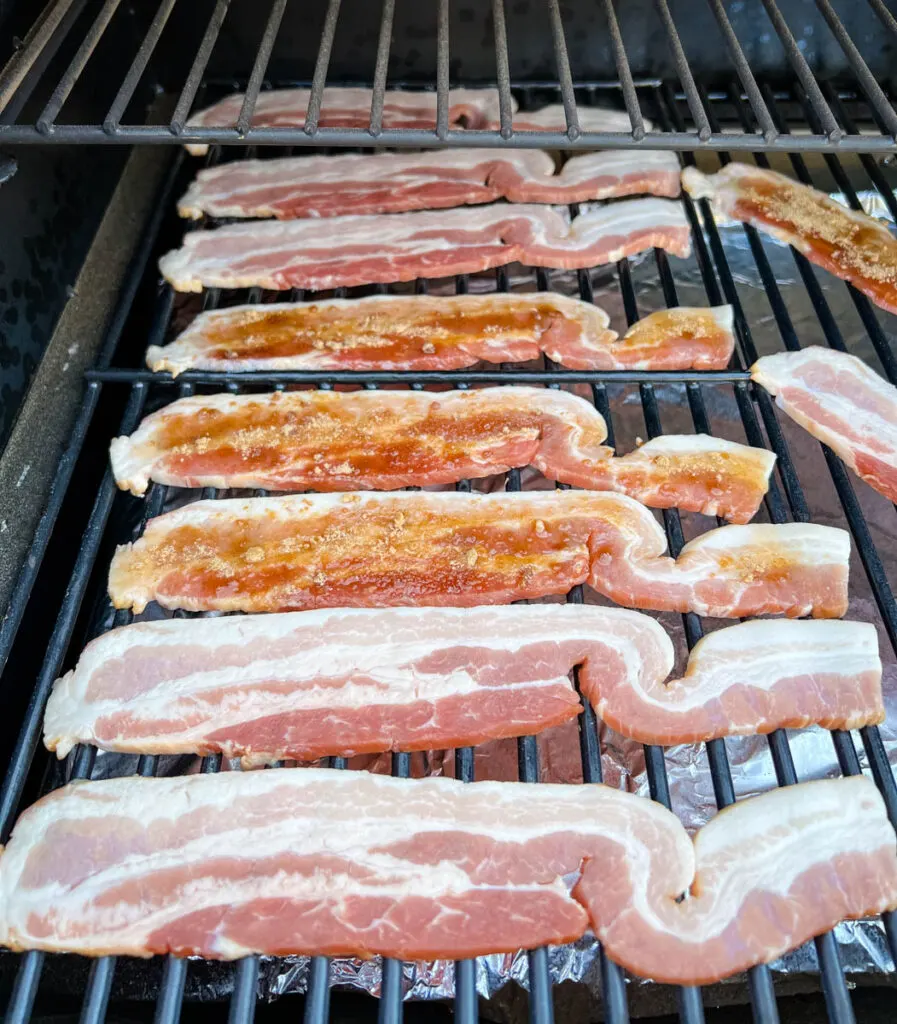 uncooked bacon on a Traeger smoker
